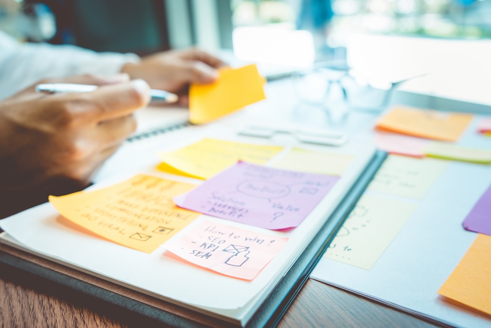 Man at desk using notes to plan website content